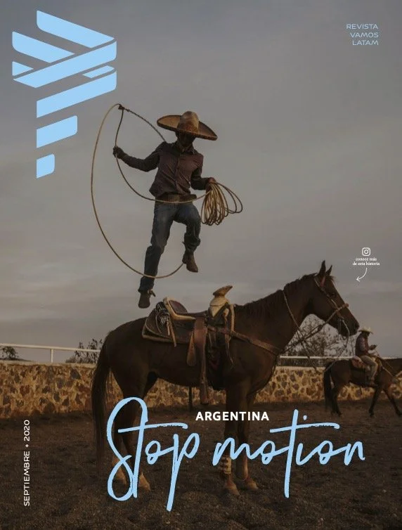 A person dressed in traditional Argentine gaucho attire, wearing a large hat, is jumping off a horse while holding a lasso. The scene is set outdoors with a cloudy sky, and a stone wall is visible in the background. Another person on horseback is seen in the background. The image includes text promoting Latin American activism, reading "Stop Motion" in prominent script, with additional text referencing Argentina and a magazine cover.