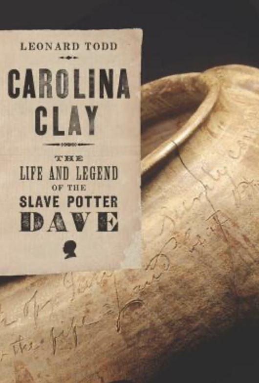 Book titled 'Carolina Clay' by Leonard Todd, about the life of slave potter Dave, placed on a clay vessel with inscriptions.