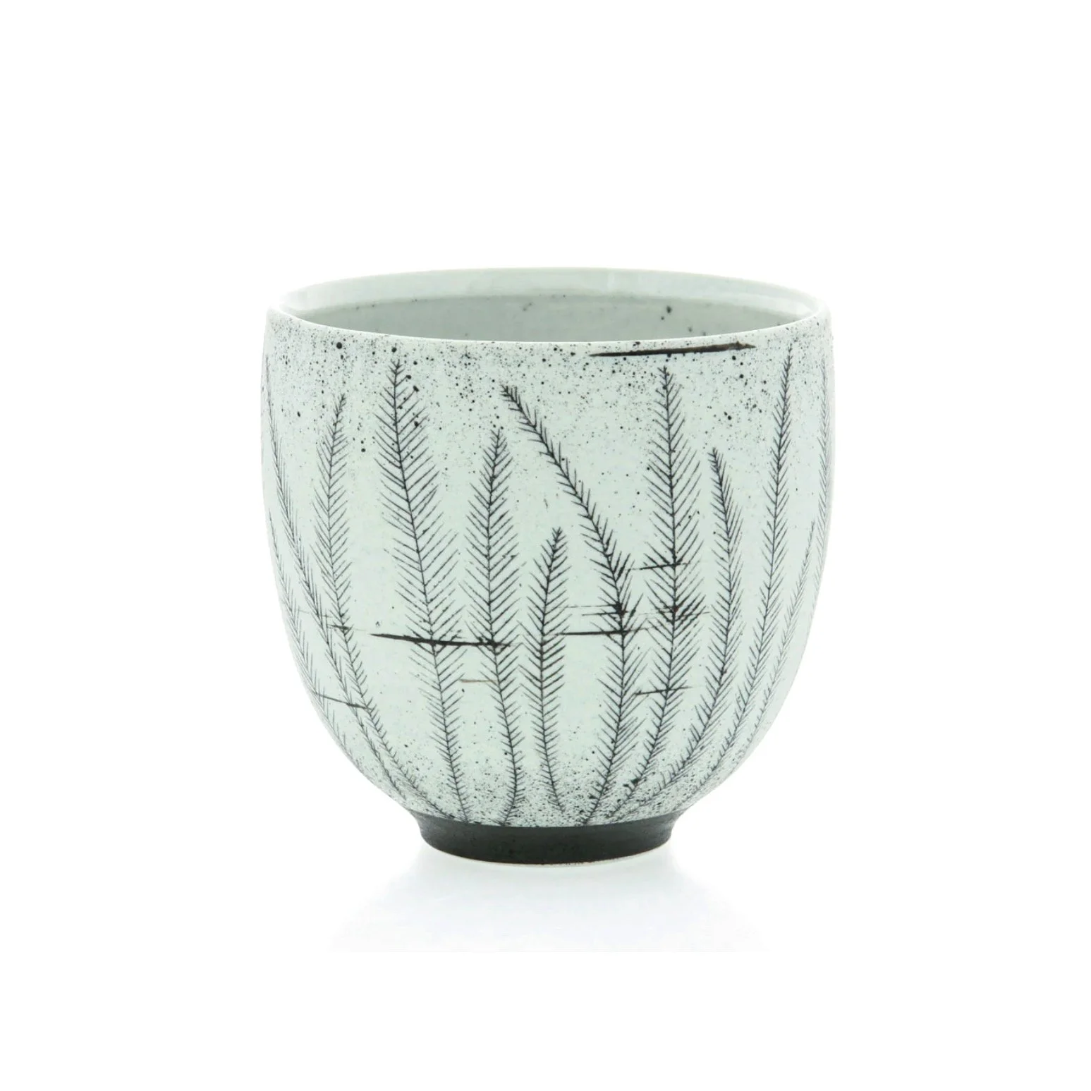 White ceramic cup with black fern-like plant pattern and black base