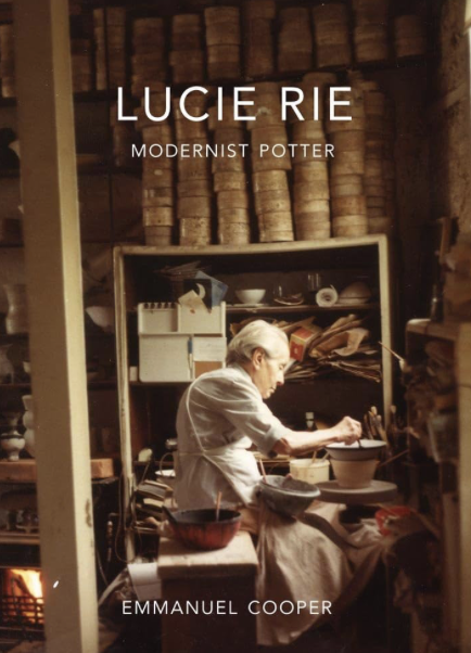Book cover titled 'Lucie Rie: Modernist Potter' featuring a woman working at a pottery studio surrounded by shelves of ceramic bowls and books.