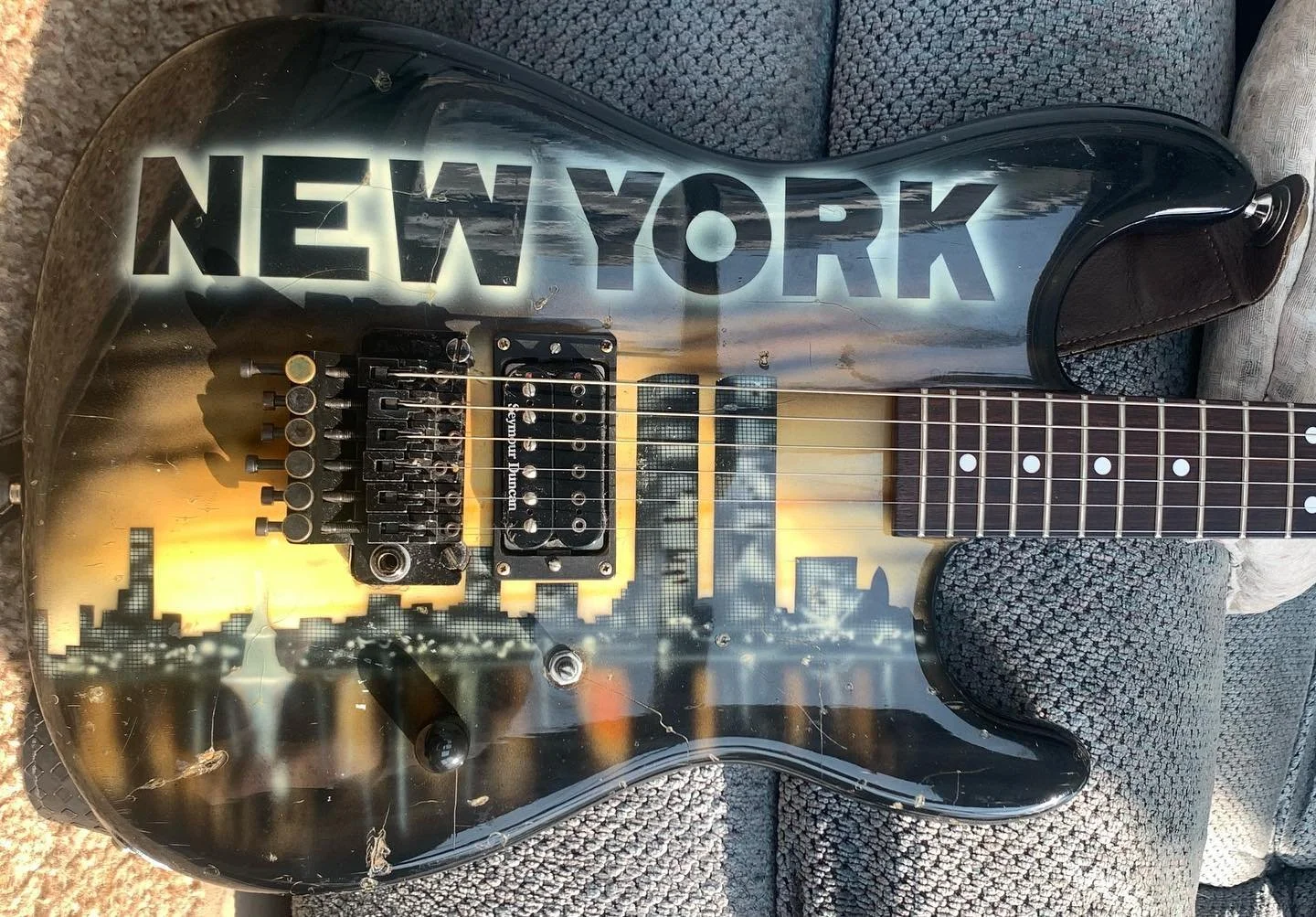 Guitar with a cityscape and sunset design, featuring the word 'NEW YORK' in large letters across the body. Kramer, Custom Dreams, Kline, Dennis Kline, Airbrushed, 80's