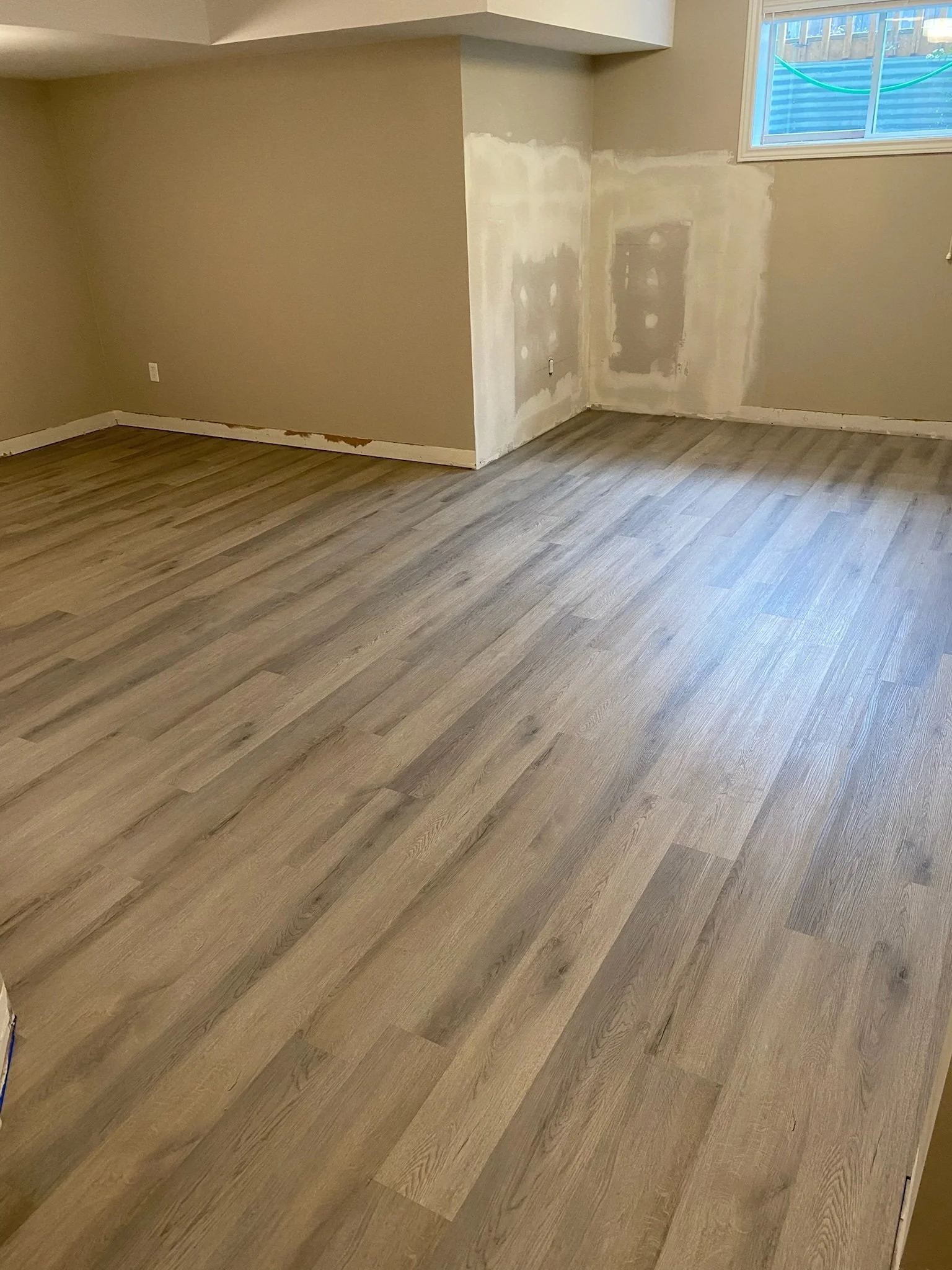 Between coats of drywall compound, the floor was installed.