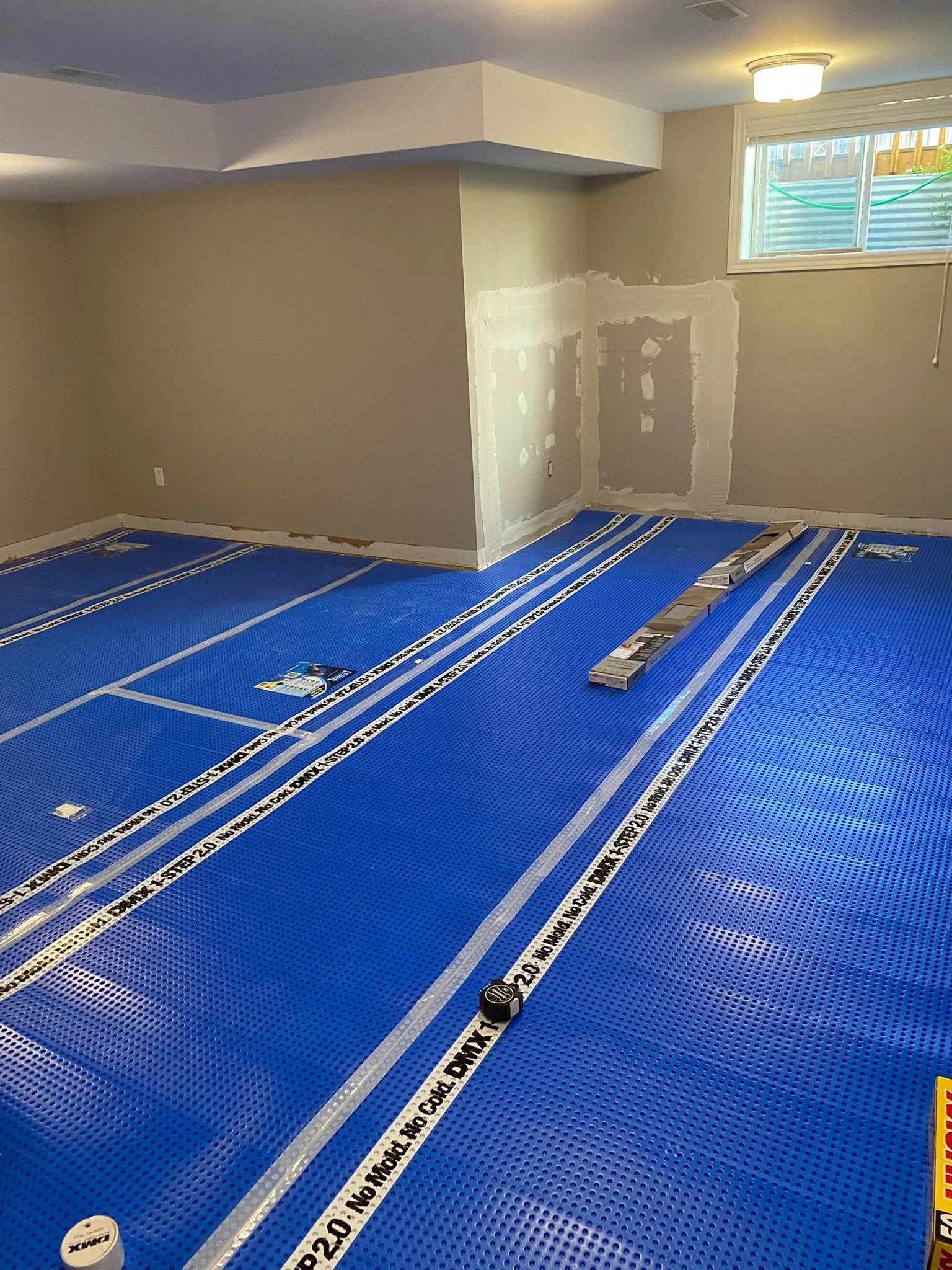 After checking the insulation, wood, and foundation for moisture or mold, I sealed everything with Zinsser Mold Stop Primer, replaced the insulation and vapour barrier, and installed the drywall. We also decided to include an underlayment that provid