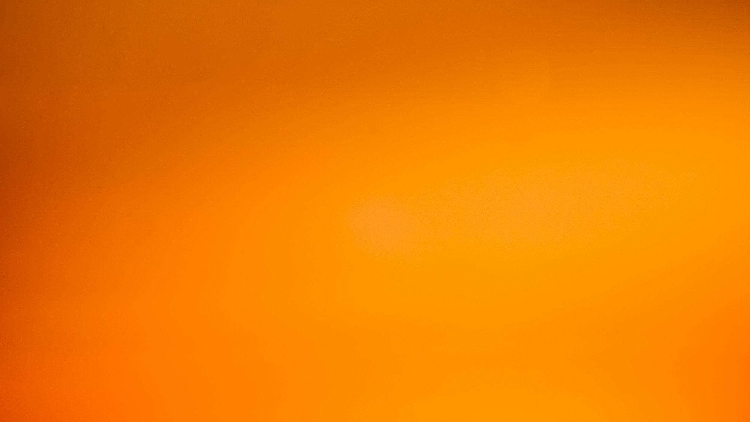 A blurred, abstract orange and yellow gradient background.
