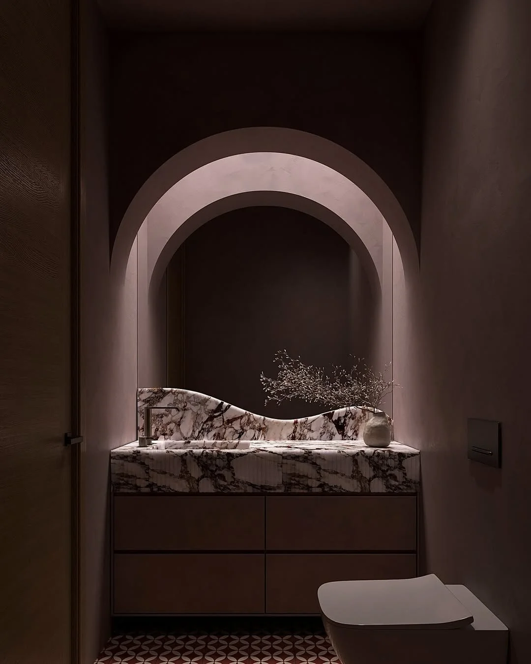 Petite salle de bain avec un lavabo en marbre beige et noir, décorée d'un vase avec des branches, sous une arche éclairée