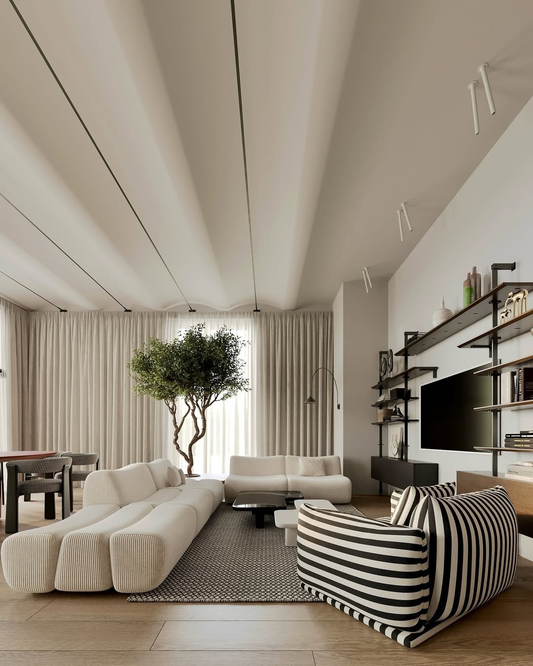 Salon moderne avec canapé blanc, fauteuil à rayures noires et blanches, arbre d'intérieur, étagères noires avec décorations, télévision, rideaux blancs et plafond avec panneaux.