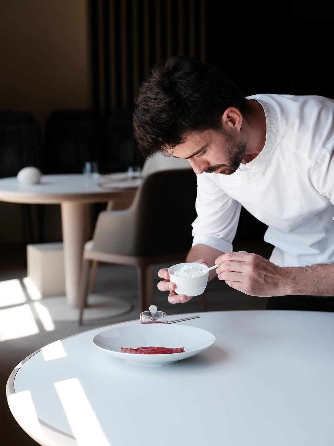 Un homme en chemise blanche mange du yaourt dans une salle élégante