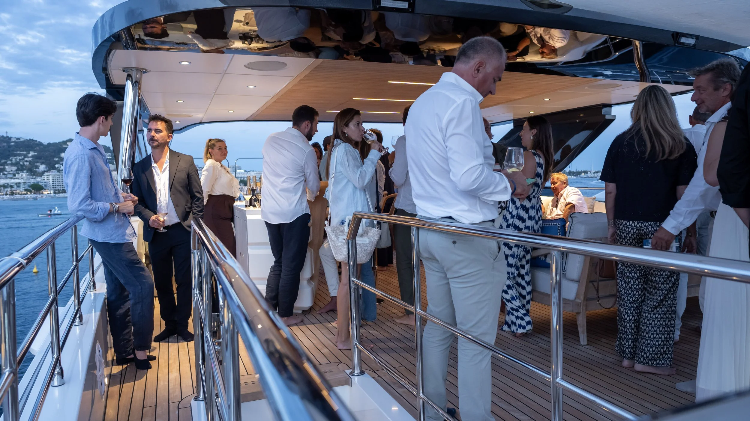 Moments d’échanges et de convivialité sur un yacht à Cannes. Photographie événementielle et direction artistique par Maison Luma, spécialiste du yachting haut de gamme.