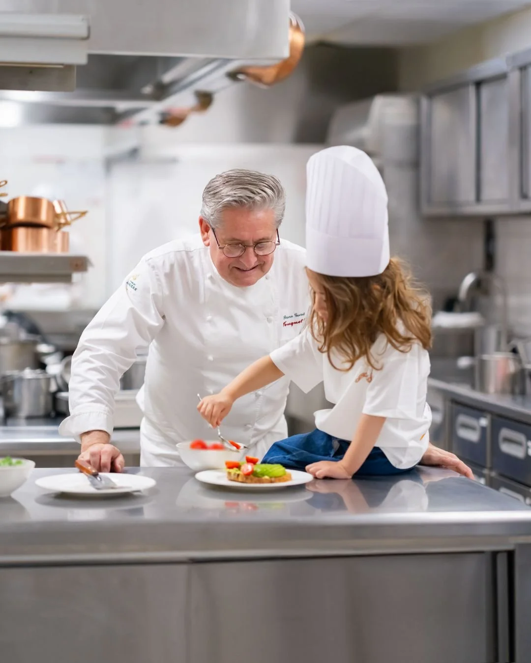 Chef en cuisine avec apprentie, capturé par Maison Luma. Photographie culinaire et direction artistique pour restaurants et établissements gastronomiques à Monaco et Nice.