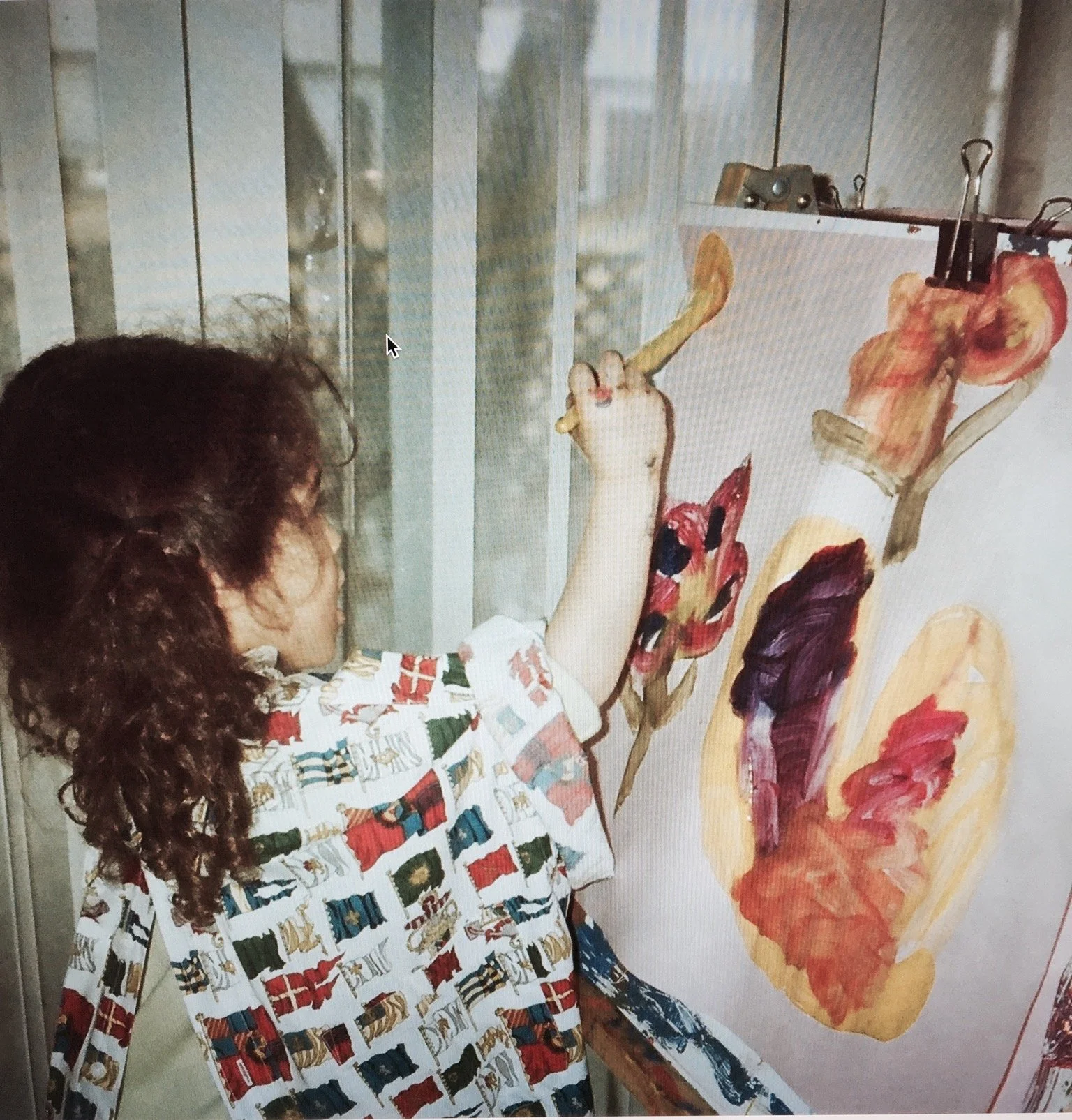 young child in a smock painting