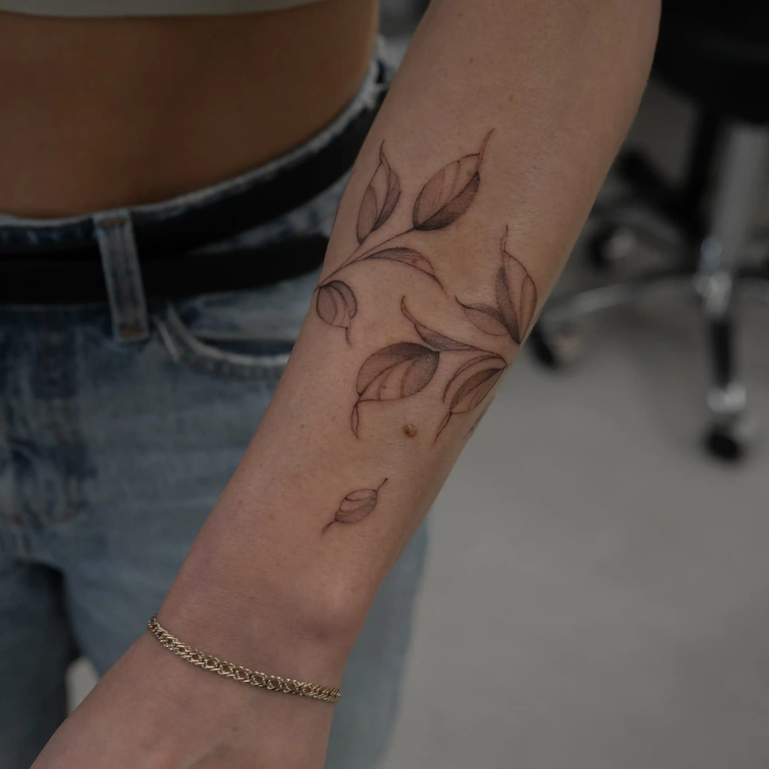 Botanical bracelet tattoo with leaves