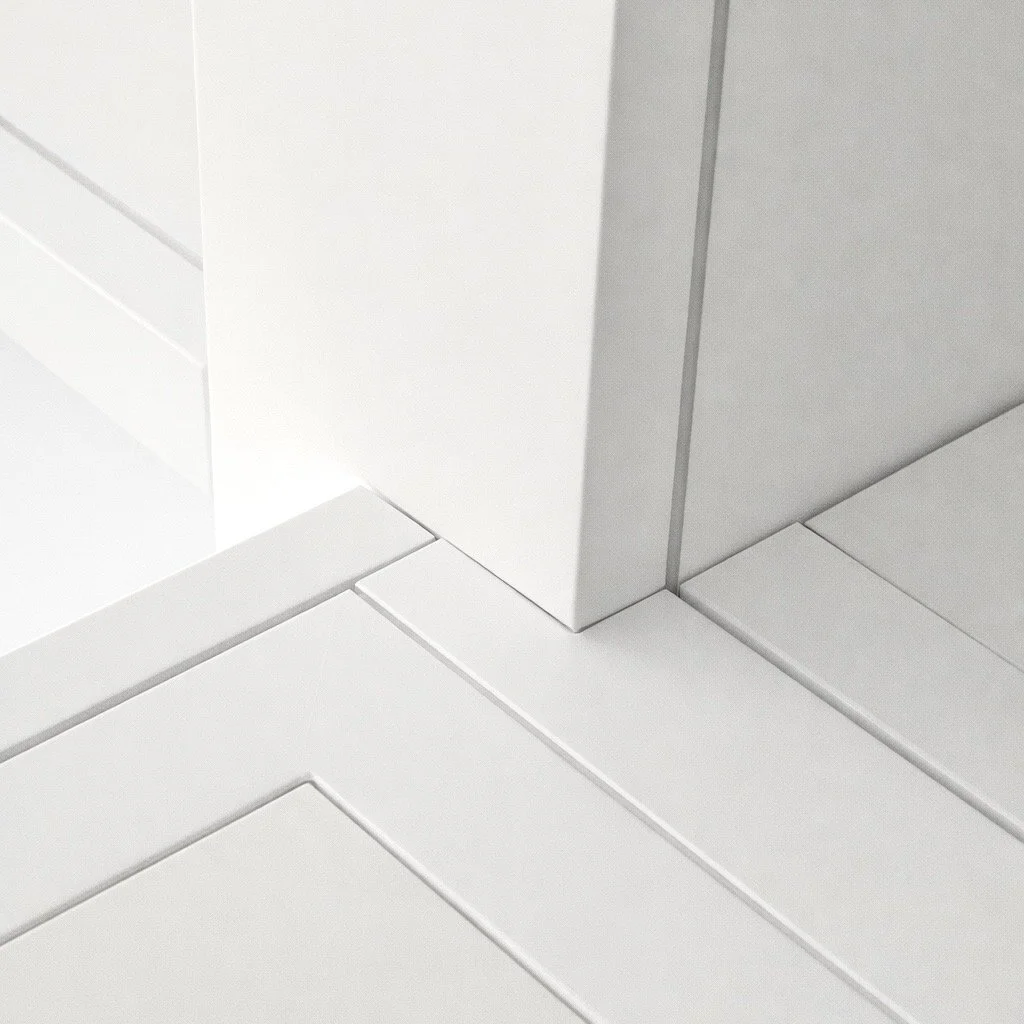 Close-up of a corner where two walls and a tiled floor meet, with the walls painted white and gray.