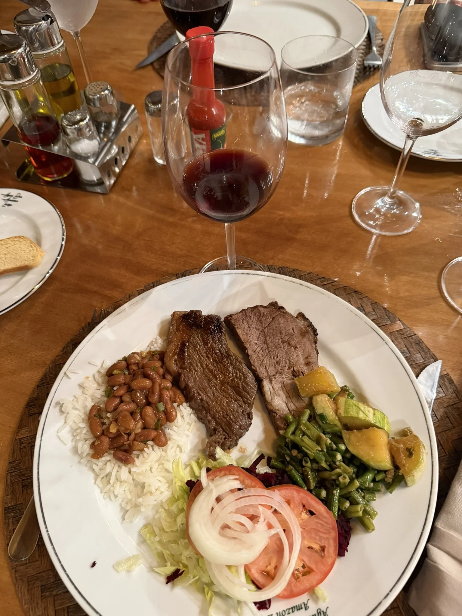 Brazilian BBQ dinner with salad, vegetables, rice, beans, and wine at Agua Boa Amazon Lodge.