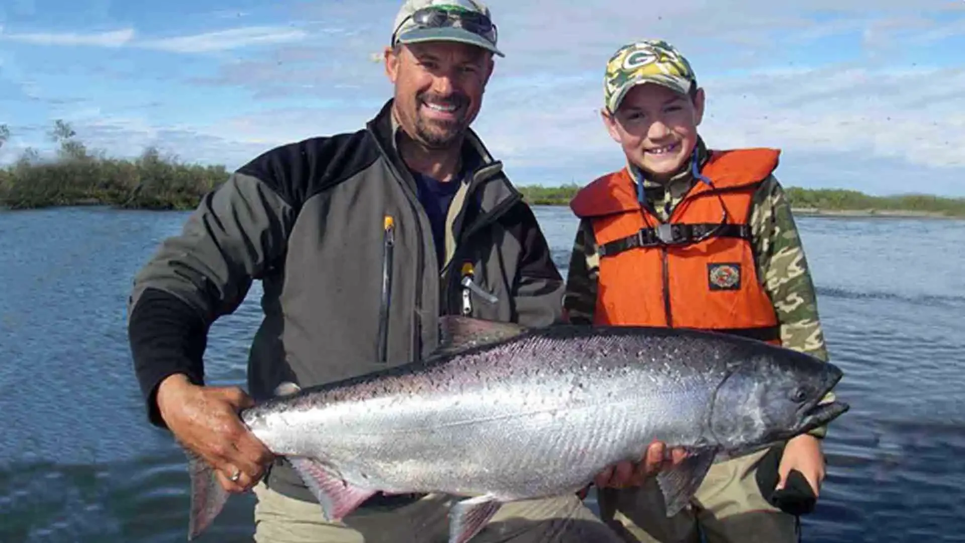 Father and son proudly display a massive King Salmon caught on Alaska's Nushagak River, guided by Dave Duncan & Sons.
