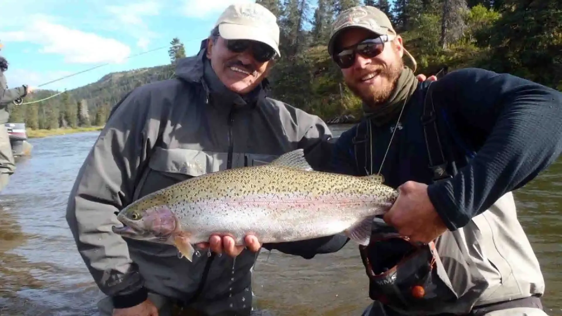 Angler and guide from Copper River Lodge holding a trophy rainbow trout caught on the Copper River in Alaska during a guided fly fishing adventure.