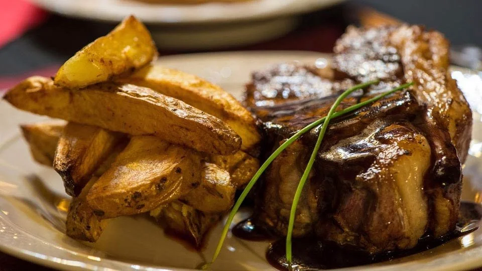 Hearty steak dinner with potatoes served at Estancia Laguna Verde Lodge in Patagonia, Argentina