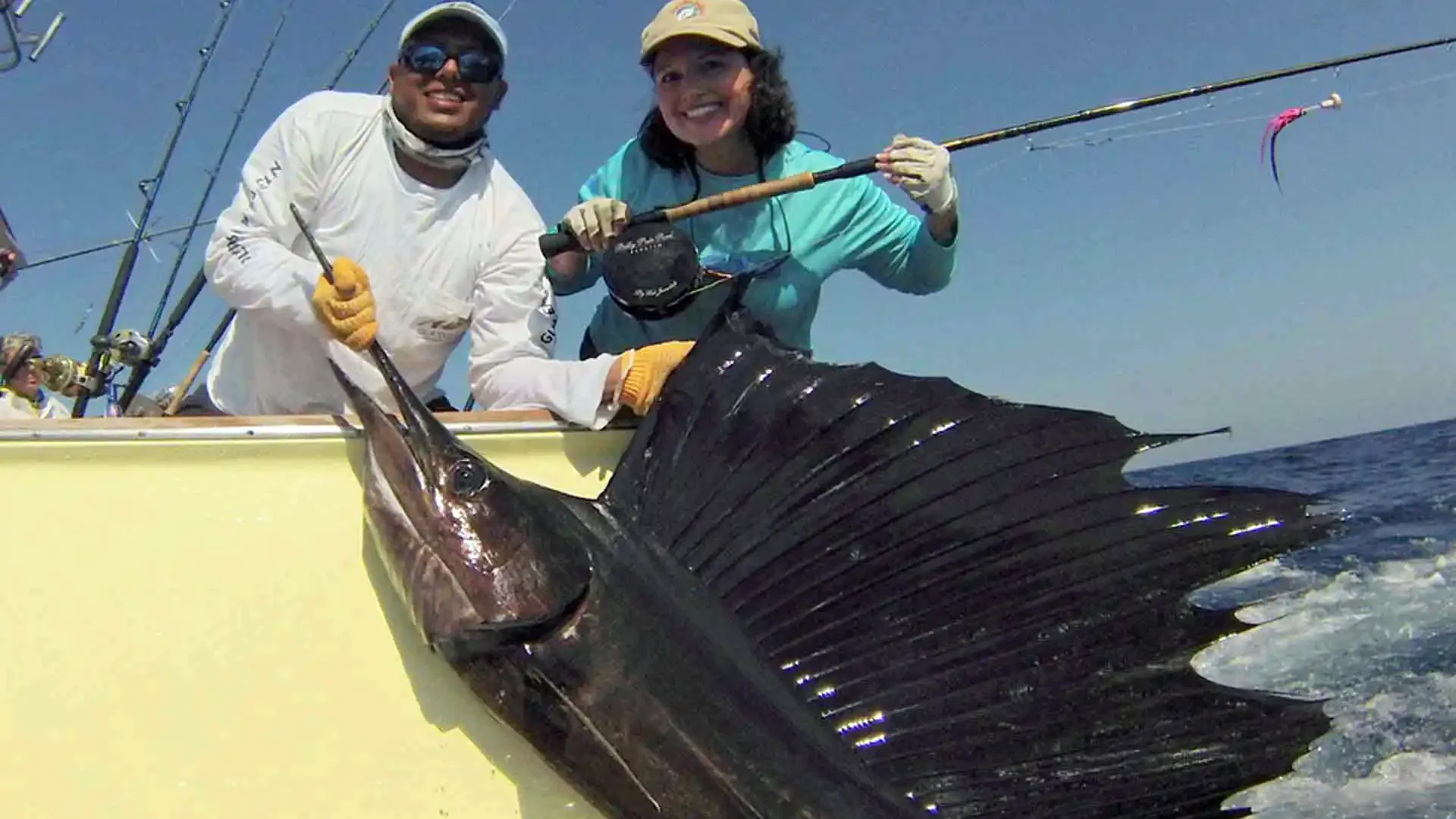 Female angler smiling with a sailfish she caught in Guatemala aboard the Allure II at Sailfish Oasis Lodge.