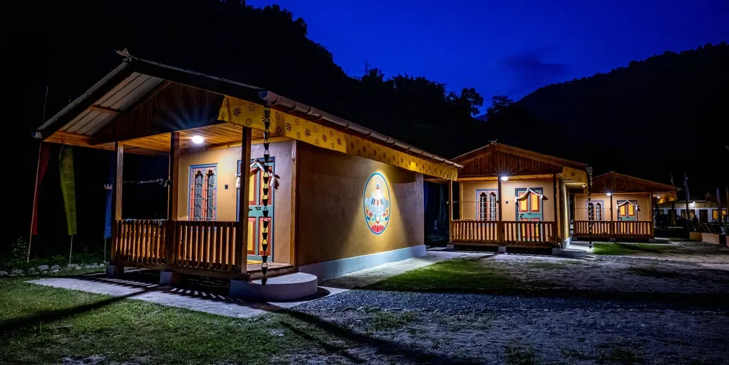 Guest cabins at Manas River Lodge on the Mangde Chhu River in Royal Manas National Park, Bhutan, featuring riverside bungalows with private decks and Himalayan forest views.