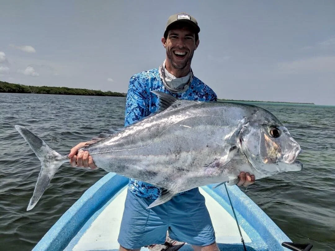Angler holding a large African pompano while fishing in Ascension Bay
