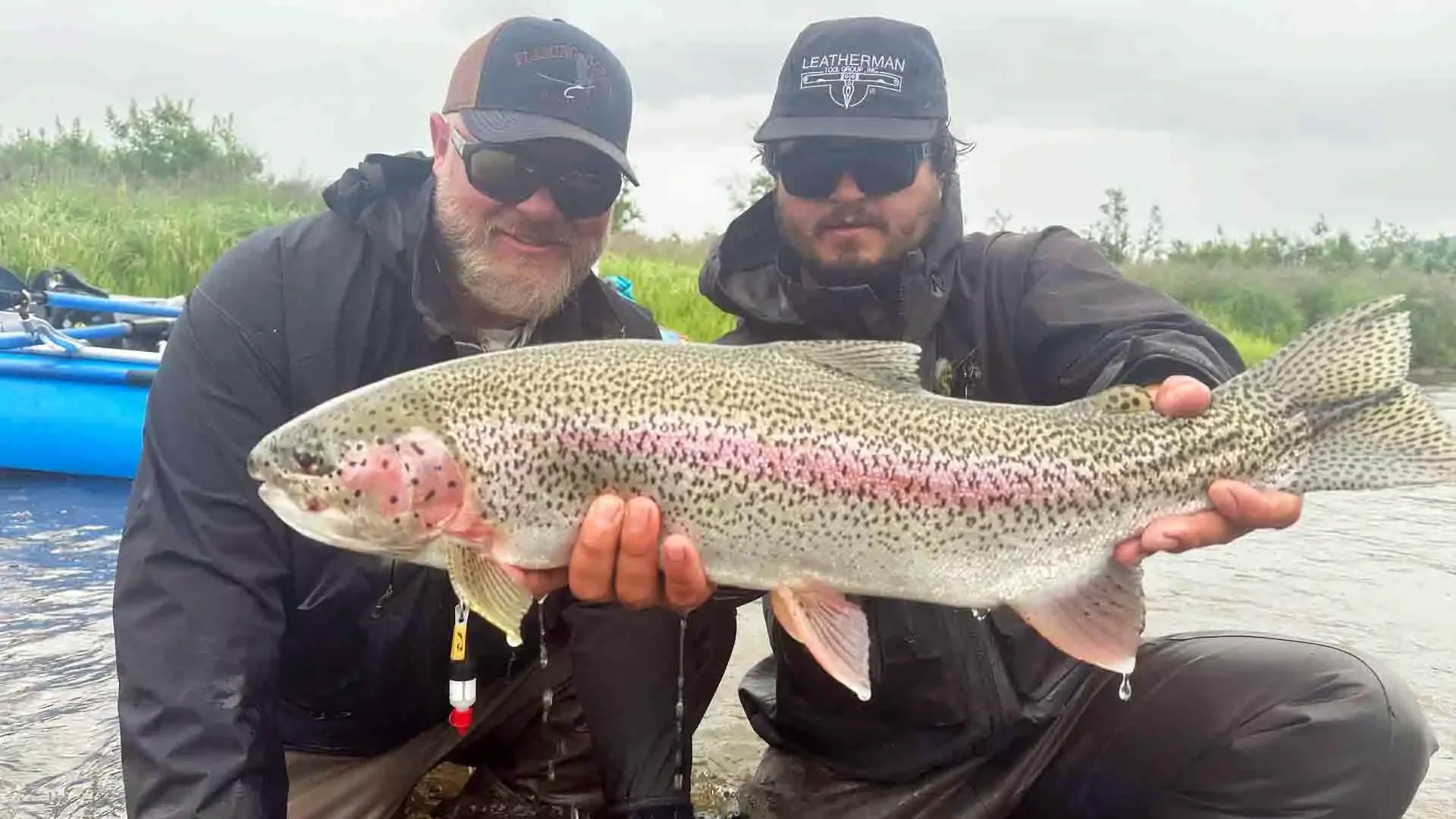 Angler and guide holding a large rainbow trout caught on a mouse pattern during a Hooked on Alaska American Creek fly fishing trip