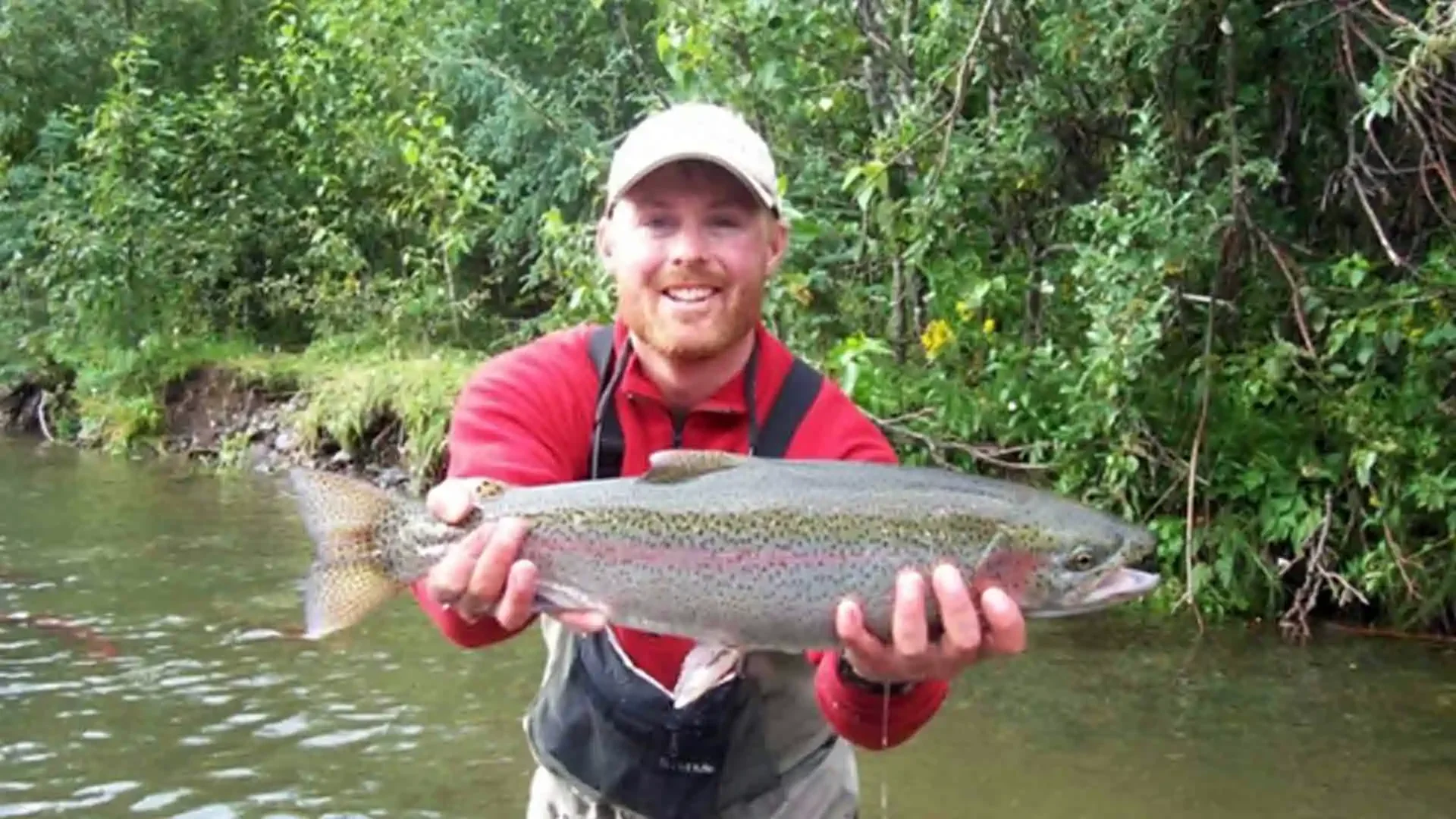 Angler holding a trophy rainbow trout caught on the Copper River in Alaska during a guided fly fishing trip.