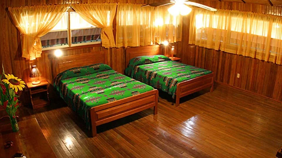 Cozy guest room with hardwood floors and two beds at Silver King Lodge in Costa Rica.
