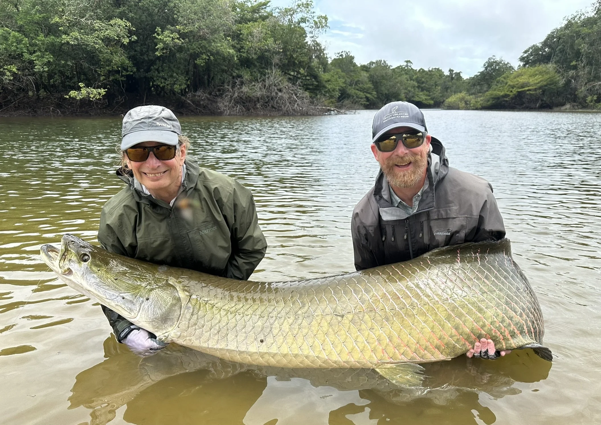 Two anglers holding a giant arapaima caught from the Agua Boa Amazon Lodge in Brazil, a top destination for exotic freshwater fishing.