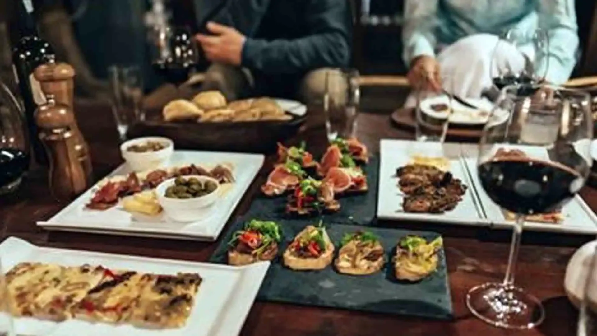 Appetizers served on white plates with wine at Tsimane Pluma Lodge, Bolivia, offering gourmet dining for fly fishing guests