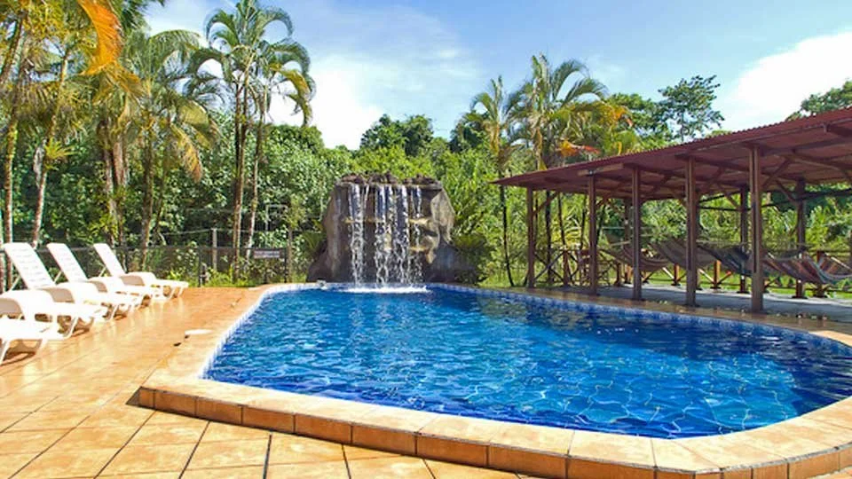 Pool with waterfall and surrounding guest seating area at Silver King Lodge.