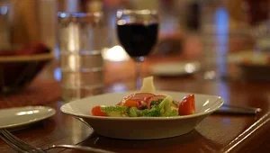 Dinner salad served with a glass of red wine
