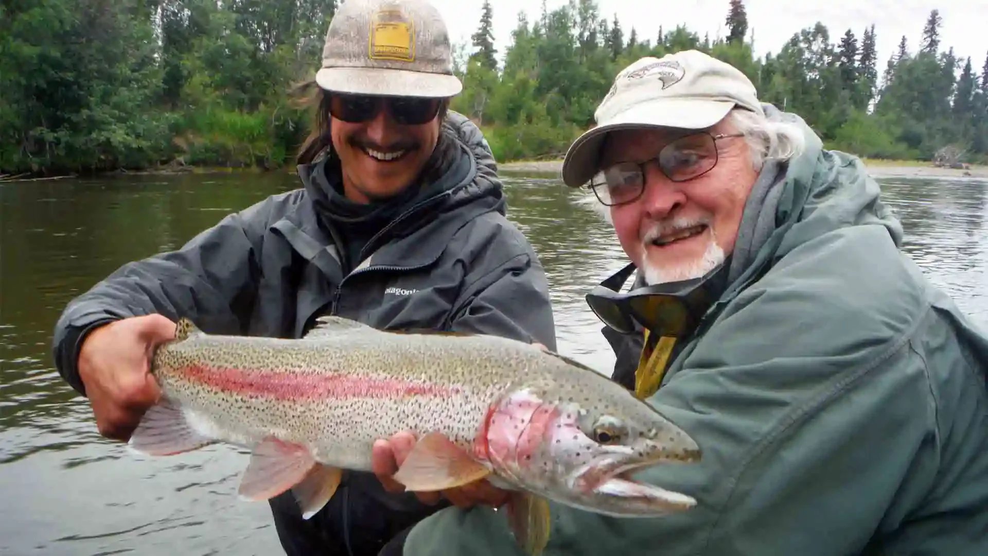 Aniak River Lodge guide with angler holding a rainbow trout on the Aniak River, Alaska