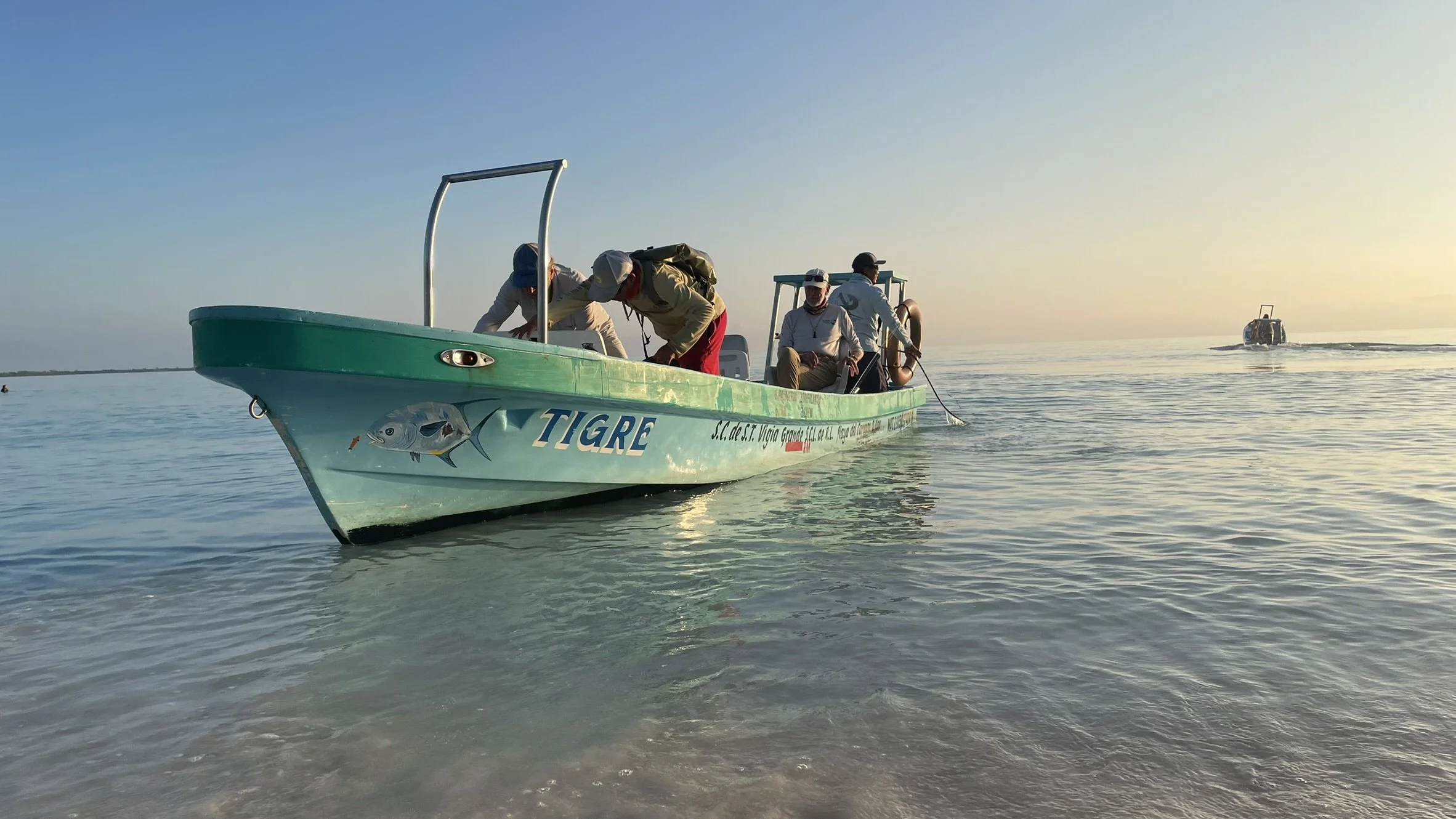 Anglers and Kay Fly Lodge fishing guides boarding a boat to start a day of fly fishing on Ascension Bay in Punta Allen, Mexico.
