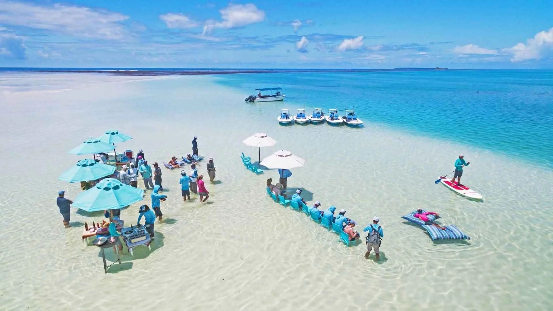 anglers from alphonse island lodge having lunch on sandy flat surrounded by clear Indian ocean waters