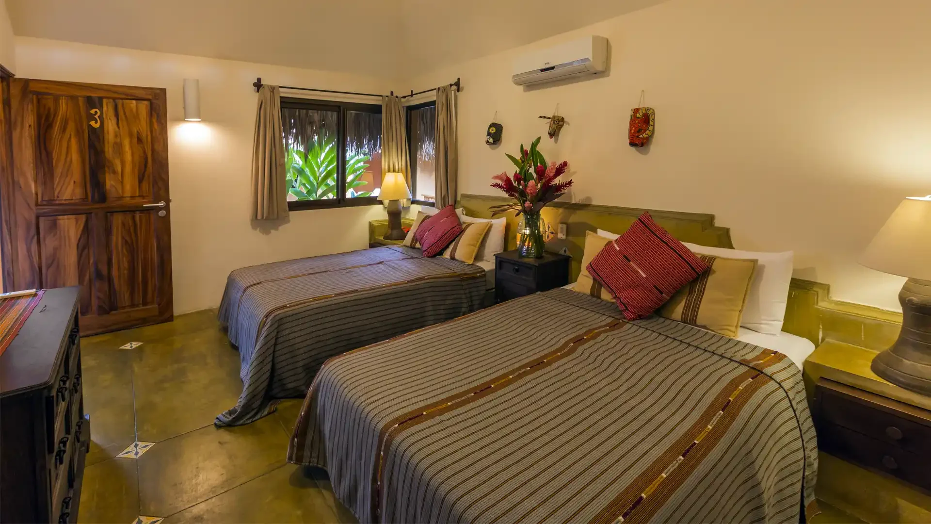 Guest accommodations at Sailfish Oasis Lodge featuring a well-appointed bedroom with two queen beds and air-conditioning.