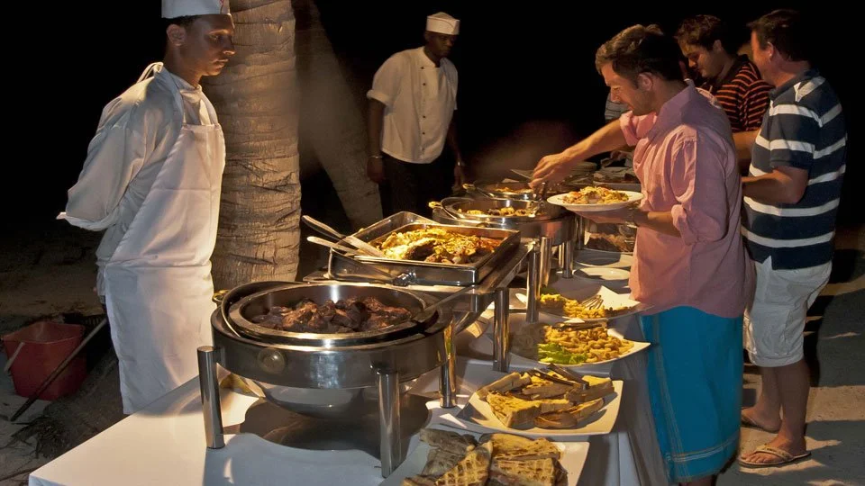 guests at alphonse island lodge serving themselves dinner from buffet