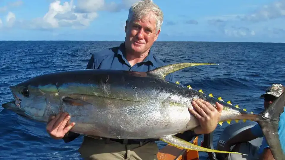 Angler holding a yellowfin tuna caught while fishing on Christmas Island, Kiribati