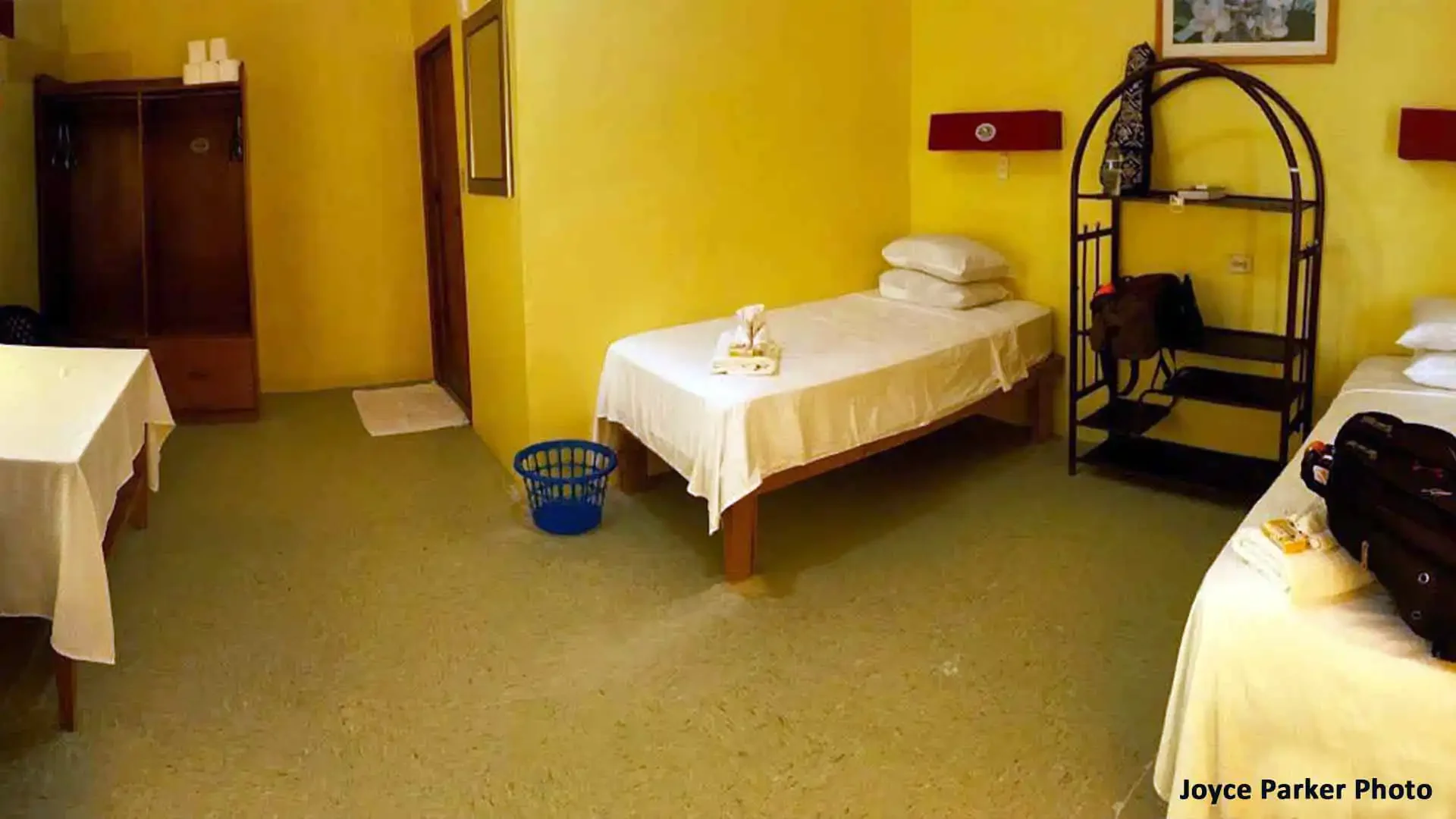 Guest bedroom at The Villages on Christmas Island featuring two beds, a table, and shelving