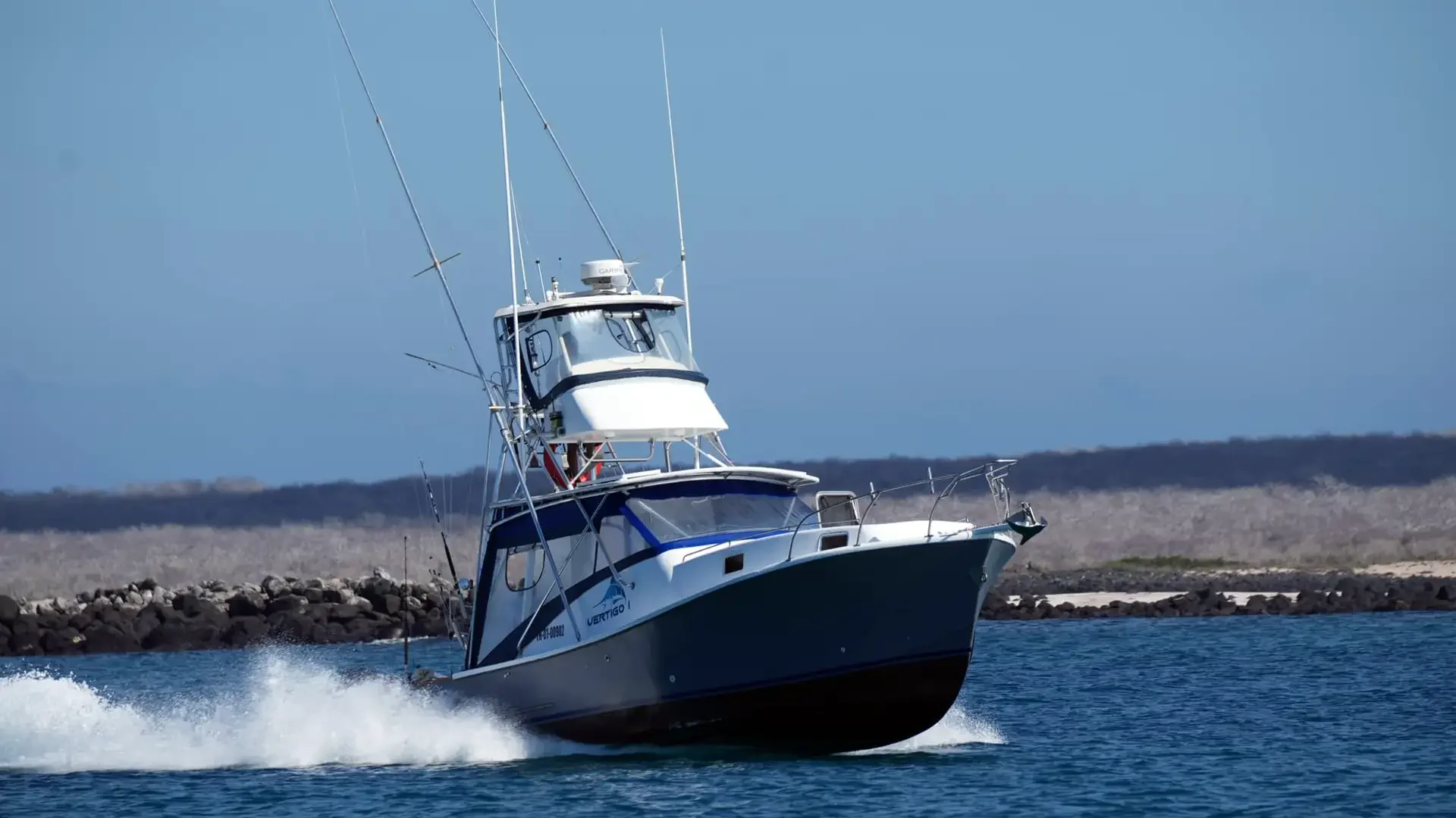 Sportfishing boat cutting through blue water in the Galapagos Islands, ideal for marlin fishing adventures.