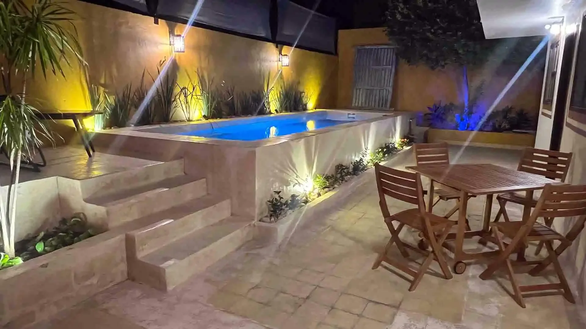 Outdoor dining area at Tarpon Town Lodge in Campeche, Mexico, next to a small swimming pool with tables and chairs for guests.
