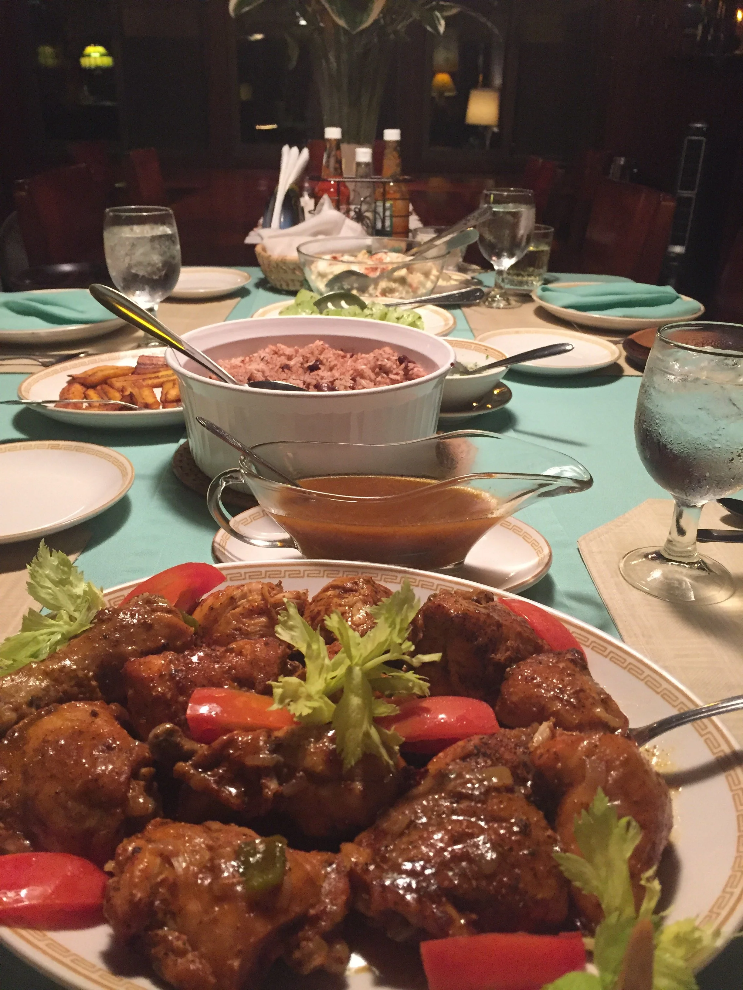 A delicious dinner spread at Belize River Lodge, featuring stewed chicken, rice, and plantains.