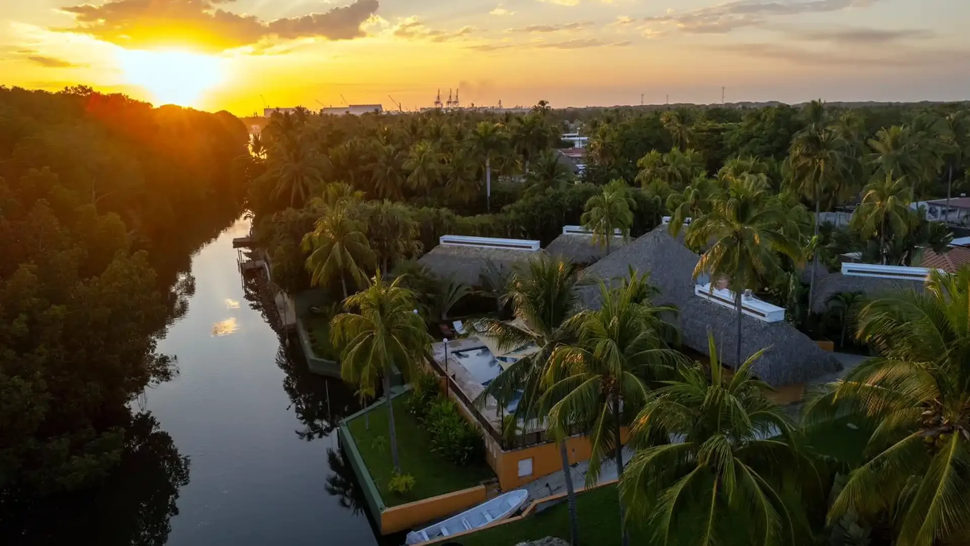 Aerial view of Sailfish Oasis Lodge in Guatemala, surrounded by palm trees at sunrise, highlighting the lodge’s tropical setting.