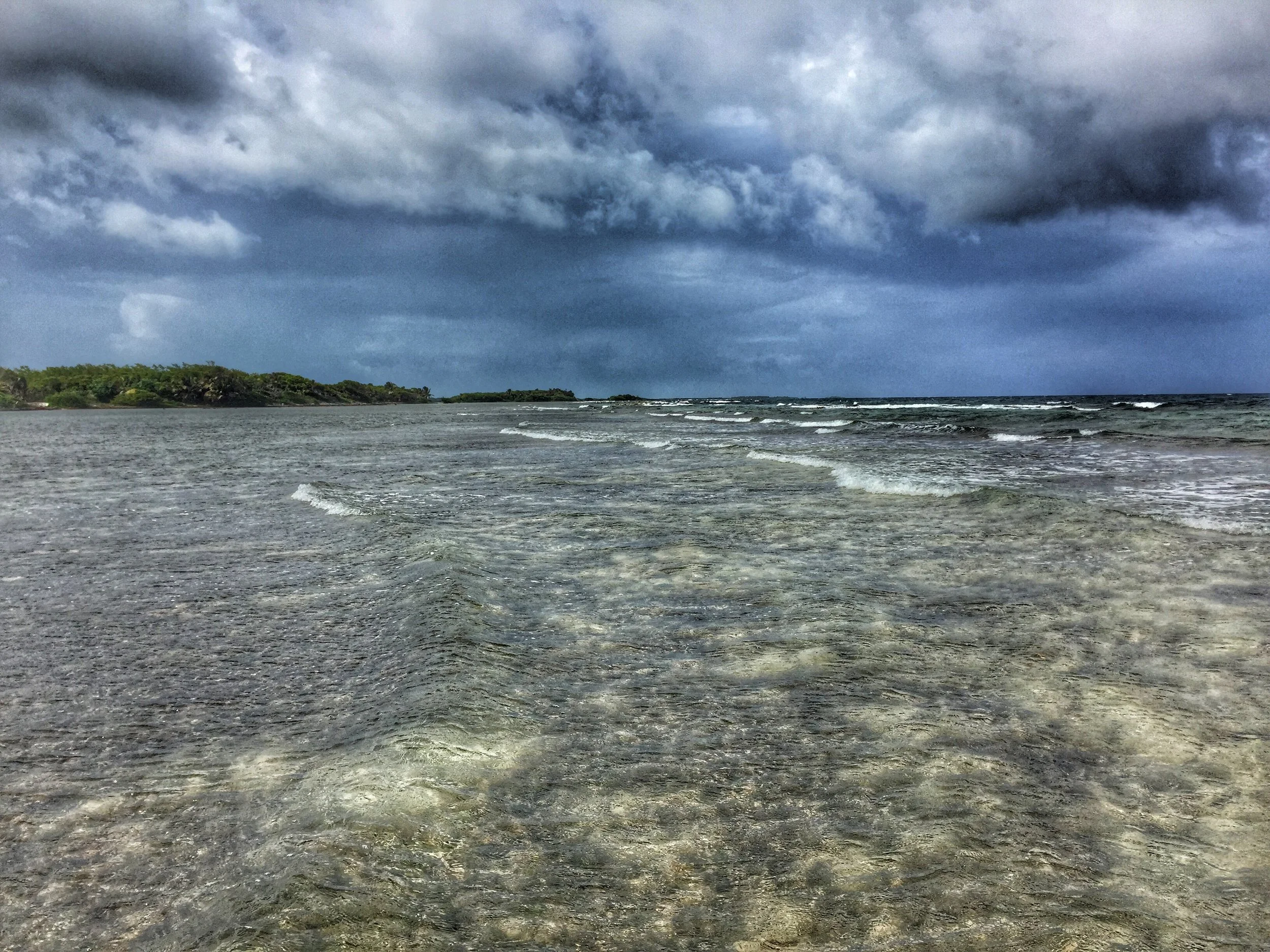 Small waves breaking over the crystal-clear waters of Turneffe Atoll, Belize
