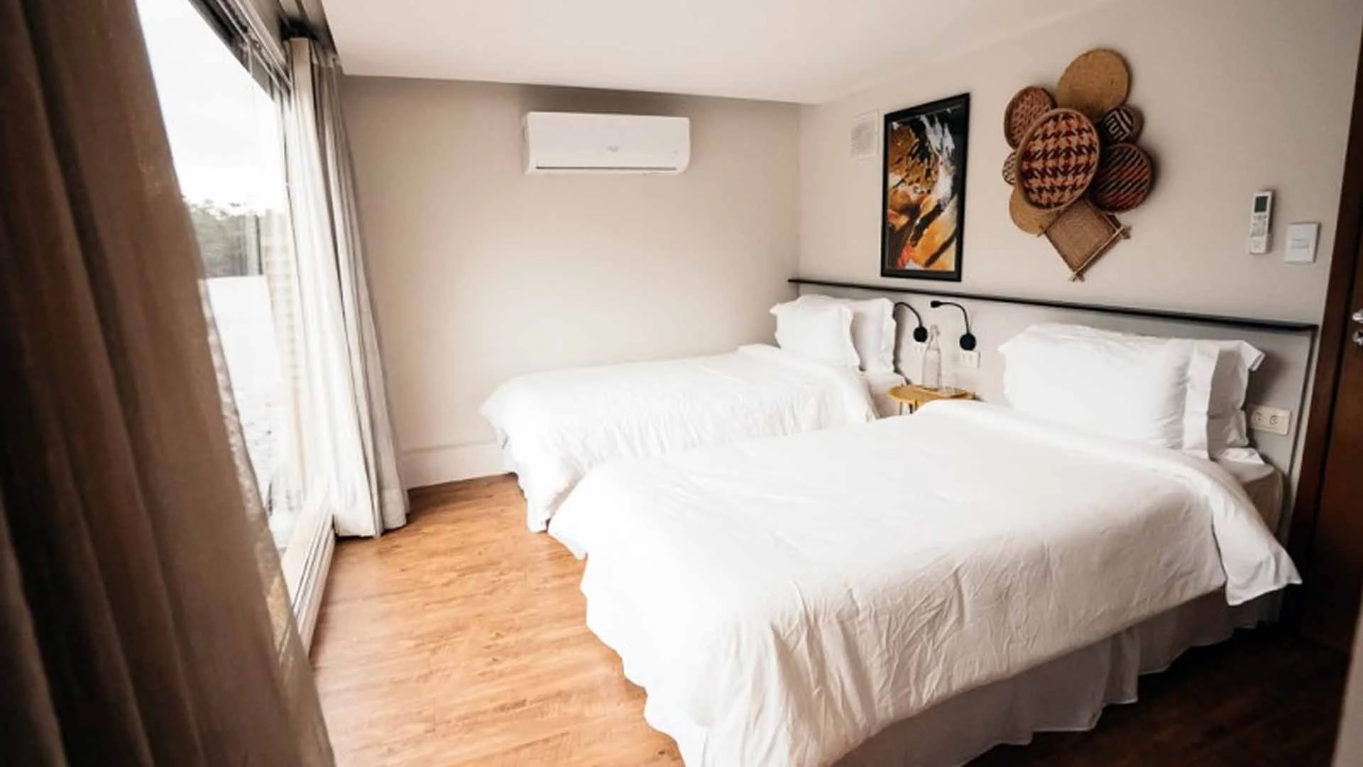 Guest suite on the Untamed Amazon liveaboard with two beds, large glass window, and wall paintings, Rio Marié, Brazilian Amazon