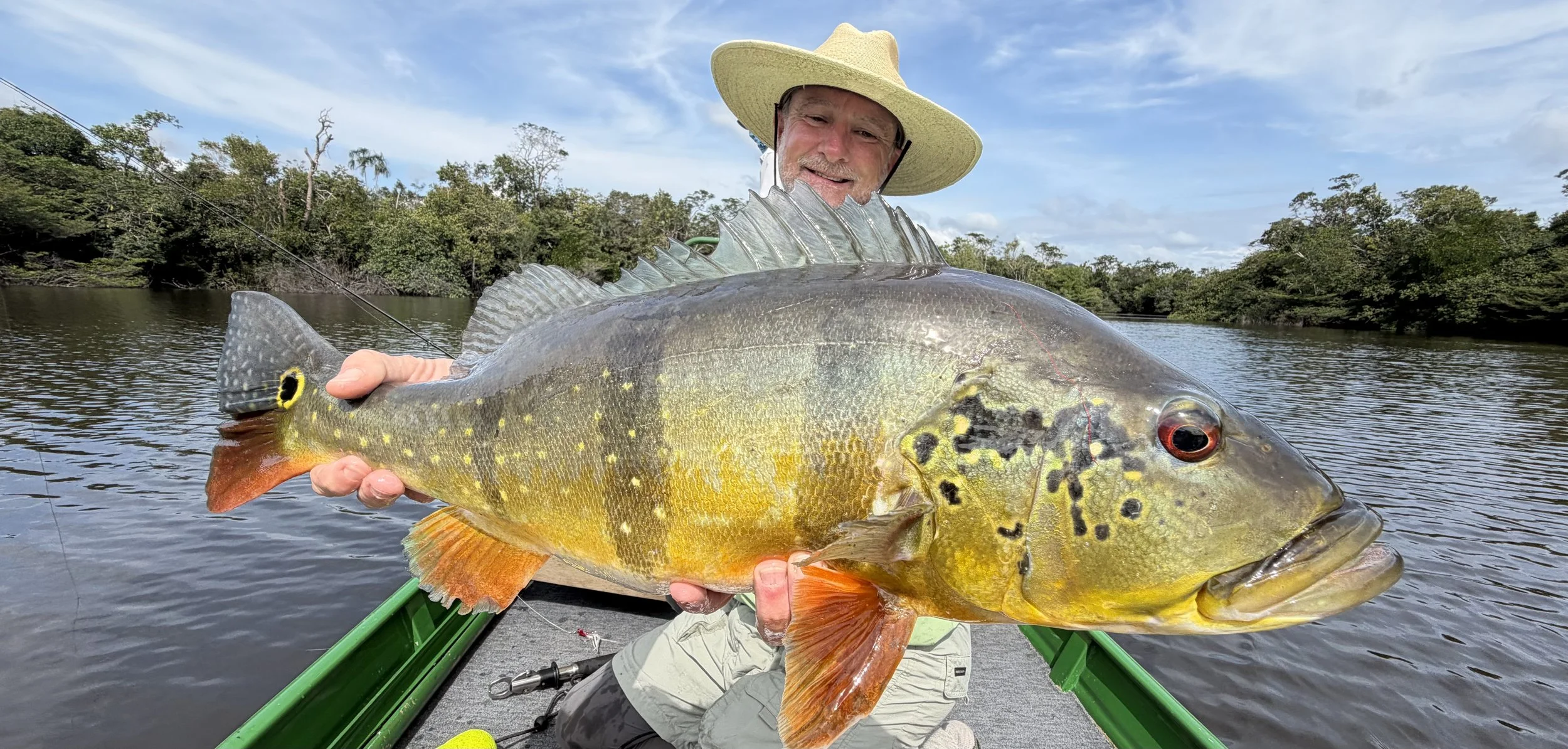Carson Oldham fly fishing on rivers and tropical waters holding large peacock bass, with additional images of him catching world-class fish on guided fly fishing trips.