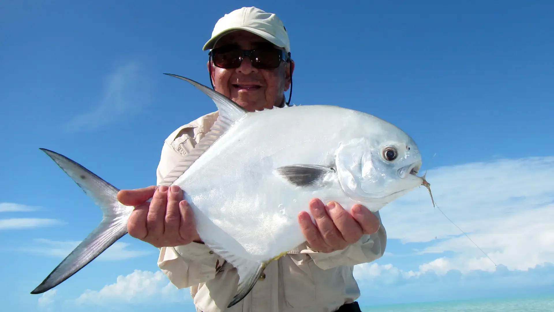 Angler holding a permit caught while fishing from Andros Island Bonefish Club, Bahamas.