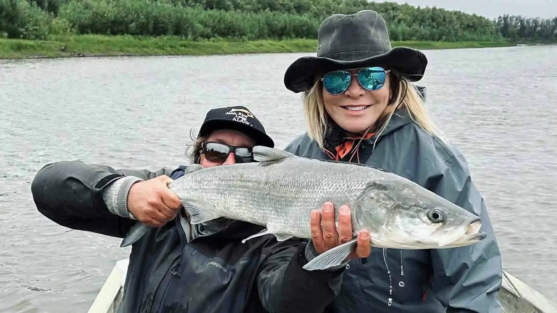 Female angler with guide holding a trophy sheefish caught on the Aniak River in Alaska during a guided fishing trip with Aniak River Lodge.