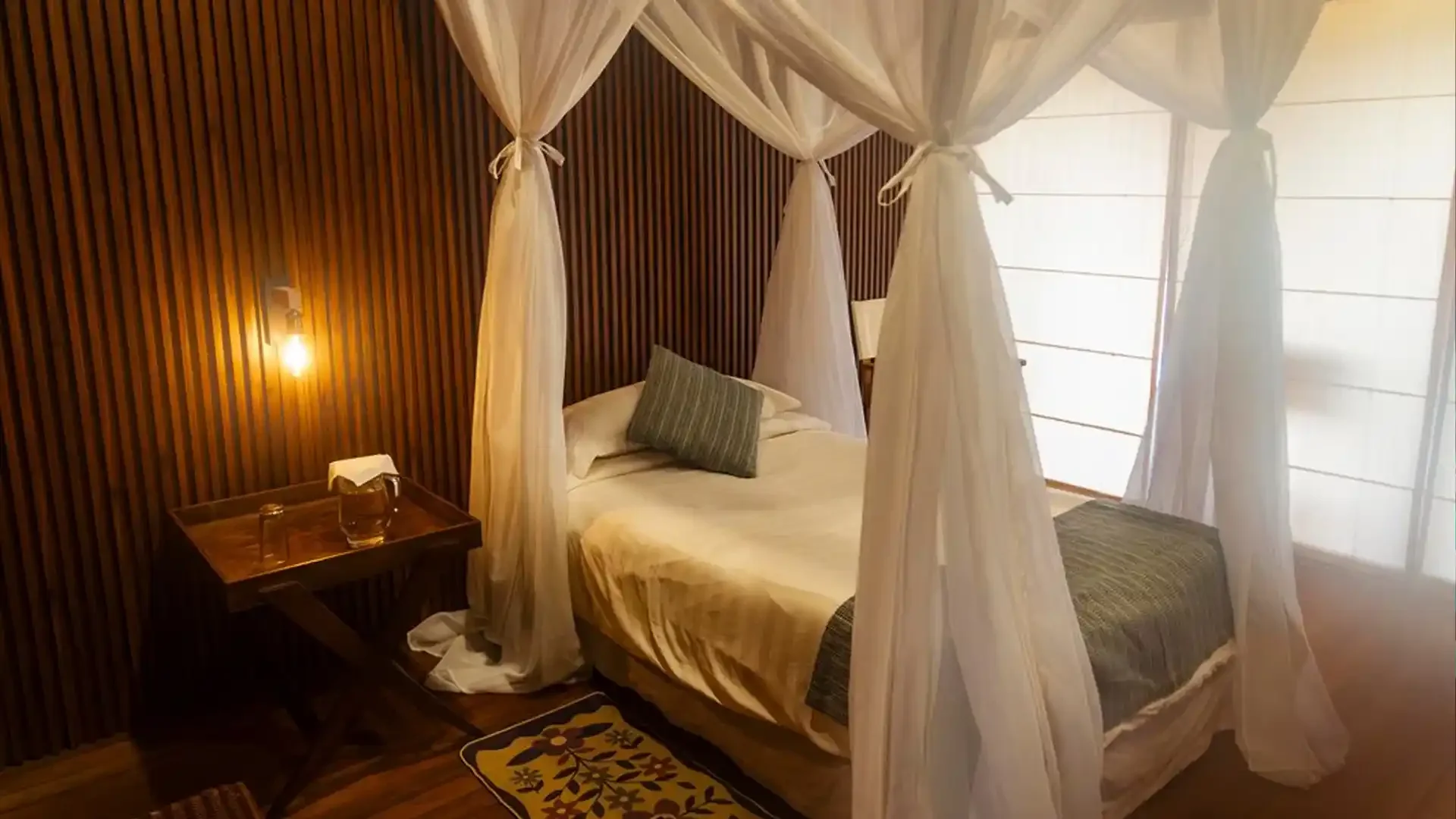Guest room with two beds and floor fan at Tsimane fishing lodge in Bolivia