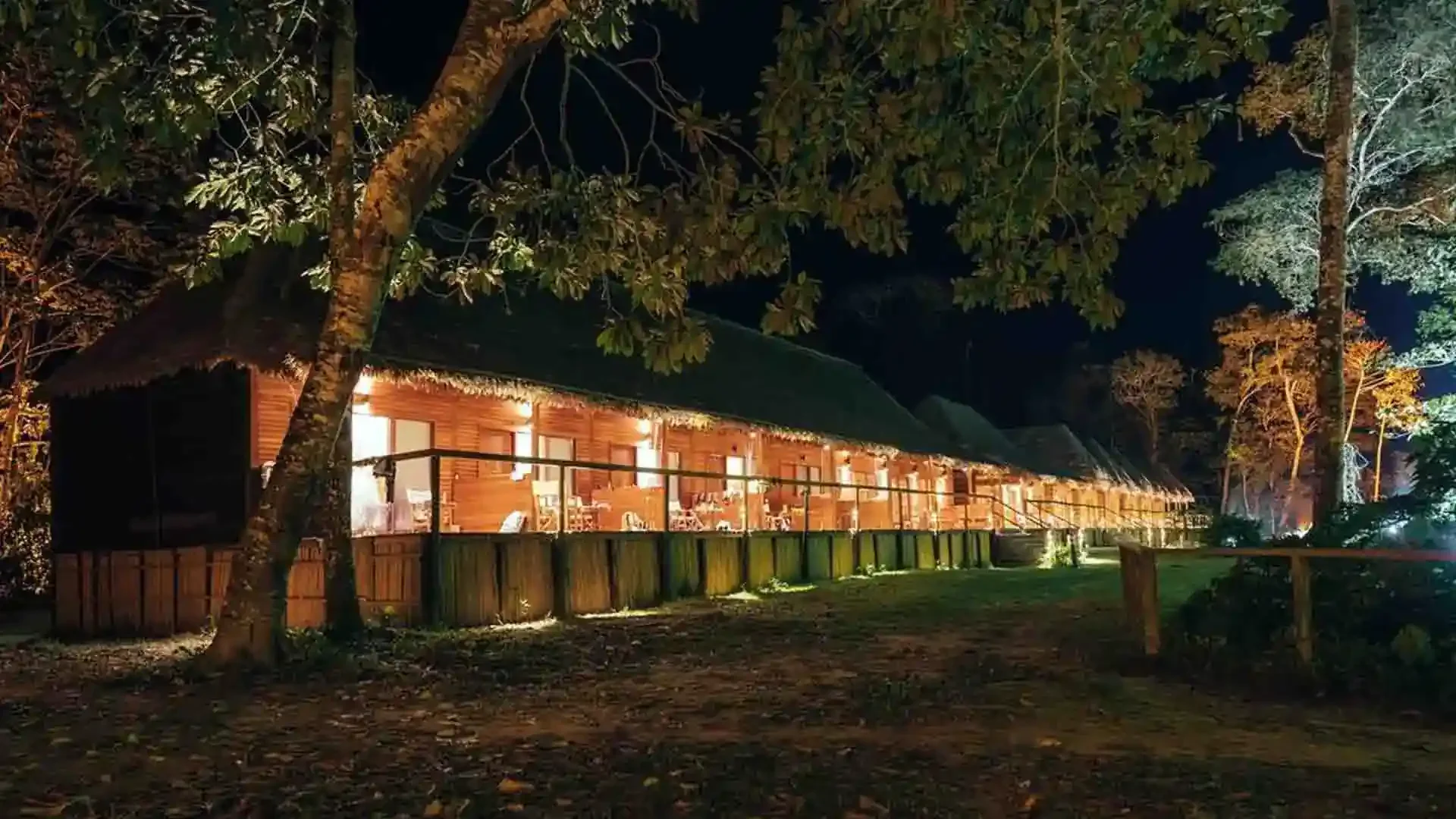 Tsimane Pluma Lodge illuminated at night in the Bolivian jungle, showcasing its lodge architecture and serene surroundings