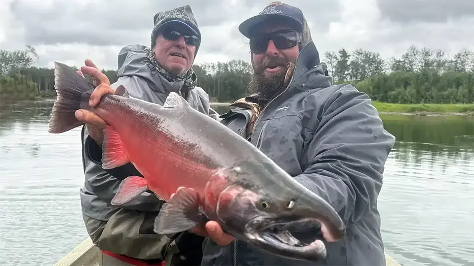 Dave Moniz holding a silver salmon at Aniak River Lodge during guided Alaska fishing trip