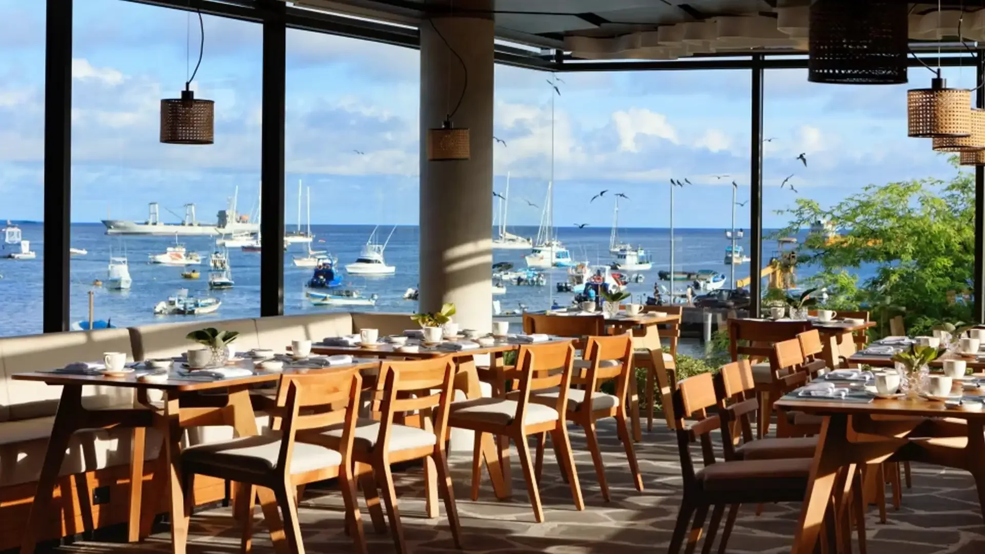 Restaurant with panoramic harbor view in Galapagos, showing boats for marlin fishing and clear blue water.